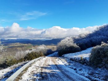 Road amidst snowcapped mountains against sky