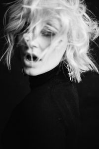 Portrait of beautiful woman against black background