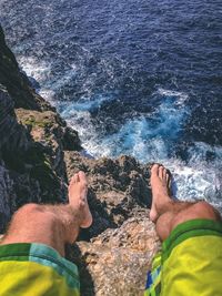 Low section of man on rock by sea