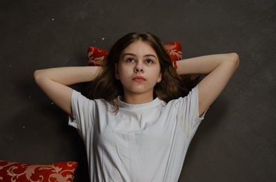 Portrait of young woman against black background