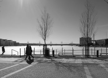 Silhouette of woman standing on tree trunk