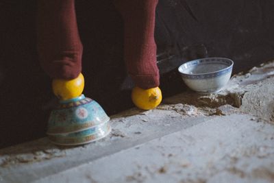 Low section of person standing on orange and bowl