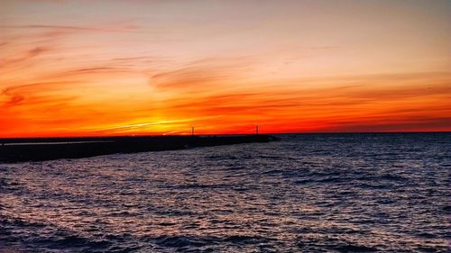 Scenic view of sea against orange sky