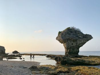 Rock formation on beach against clear sky