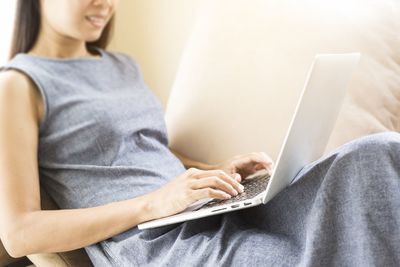 Midsection of man using mobile phone at home