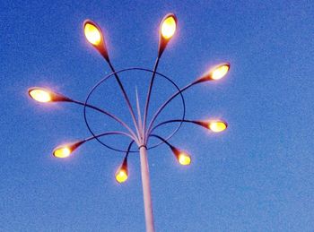 Low angle view of illuminated light bulb against sky