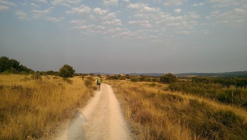 Road passing through landscape against sky