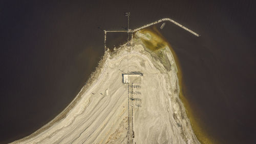 Low angle view of wind turbines on sand