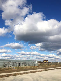 Road by buildings against sky in city