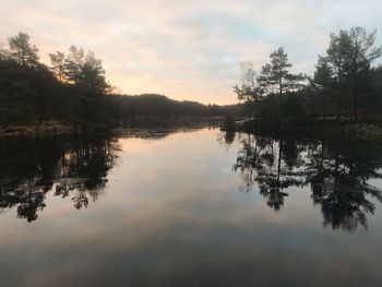 Scenic view of lake against sky at sunset