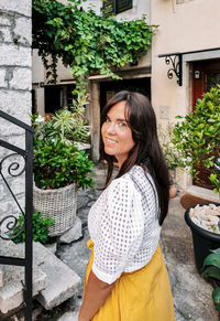 Young woman smiling at camera, old town, houses, architecture, lifestyle, travel.