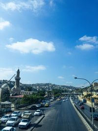 Cars on road in city against sky
