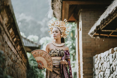 Portrait of woman standing against wall