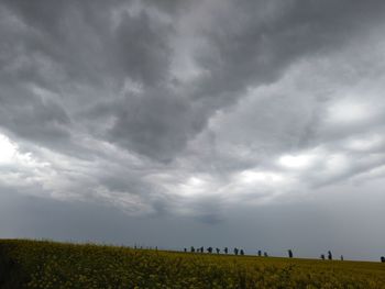 Scenic view of field against storm clouds