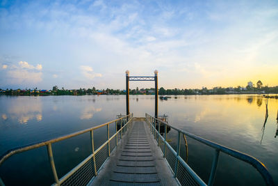 Jetty on lake against sky during sunset