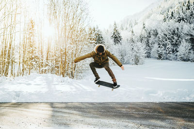 Man in mid-air skateboarding over road