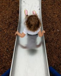 High angle view of girl sliding down at playground