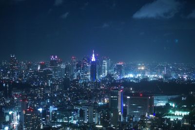 Illuminated cityscape against sky at night