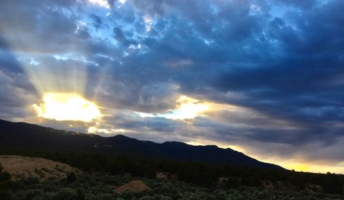 Scenic view of silhouette mountains against dramatic sky