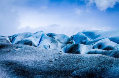 Scenic view of snow covered mountain against blue sky