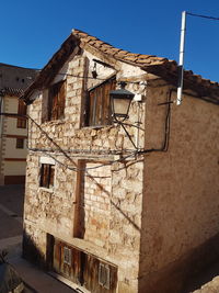 Low angle view of old building against clear blue sky
