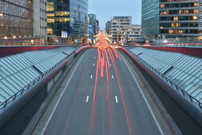 Light trails on road amidst buildings in city
