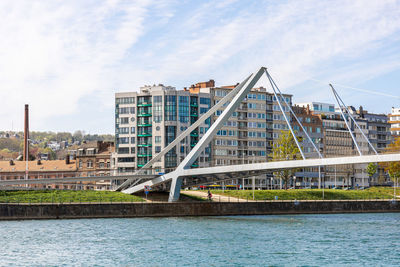 Bridge over river against buildings in city