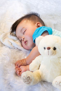 High angle view of cute baby boy sleeping on fur sheet at home