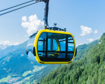 Low angle view of overhead cable car against blue sky