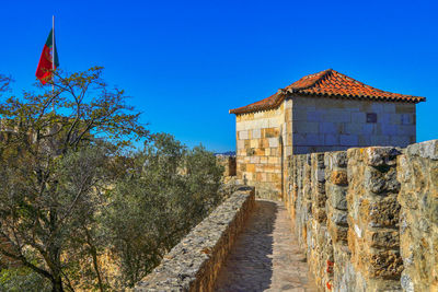 Built structure by building against blue sky. castle, lisbon, portugal 