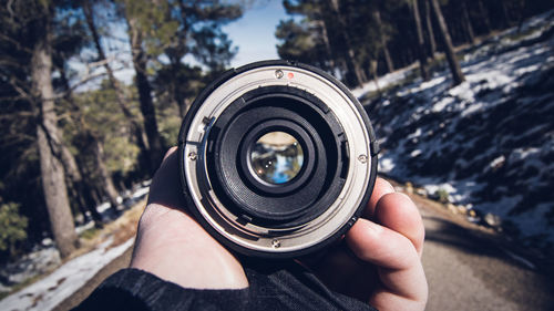 Cropped image of hand holding lens