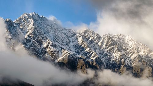 Panoramic shot of snow covered mountains against sky