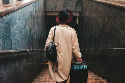 Stylish woman with a suitcase get down the stairs of the train station