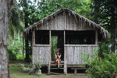 Rear view of woman sitting in abandoned house