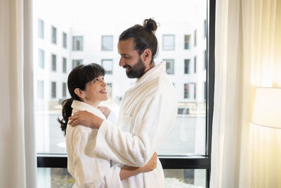 Side view of couple standing at home