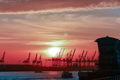 Scenic view of hamburg port against sky during sunset