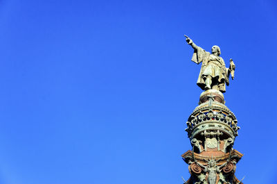 Low angle view of statue against blue sky