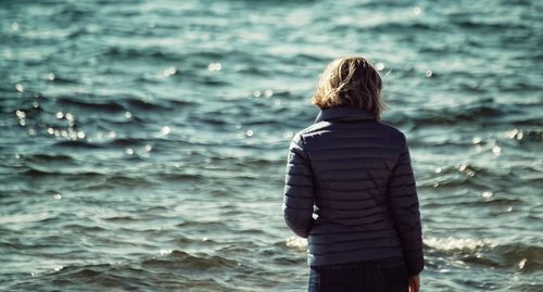 Rear view of woman standing in sea