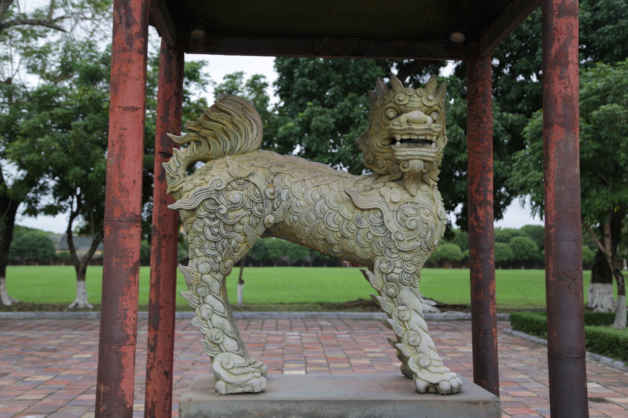 STATUES IN PARK AGAINST TEMPLE