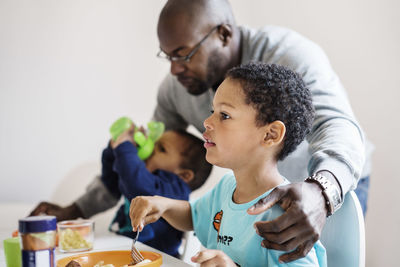 Father with sons having food in house