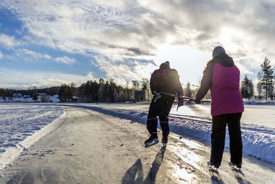 Rear view of people walking on road in winter