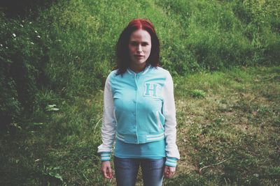 Portrait of beautiful young woman standing on field