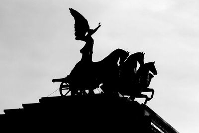 Low angle view of silhouette statue against sky