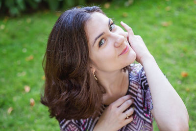 Side view of young woman sitting on field