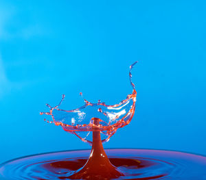 Close-up of water splashing against blue sky