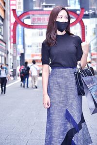 Full length portrait of woman standing in city