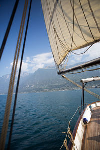 Close-up of boat sailing on sea against sky