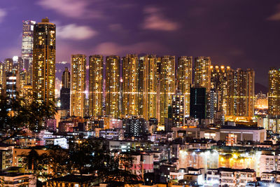 Illuminated cityscape against sky at night