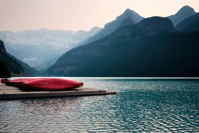 Red boat in lake against mountains