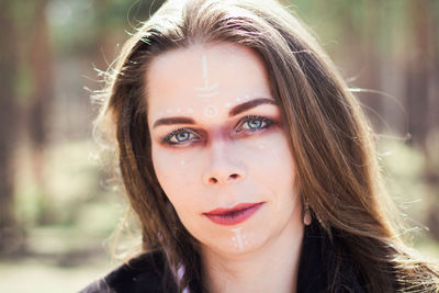 Close up woman with traditional shaman signs on face portrait picture